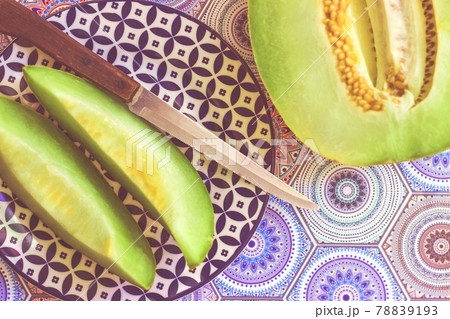 Half and sliced melon on blue colorful background; food background 78839193