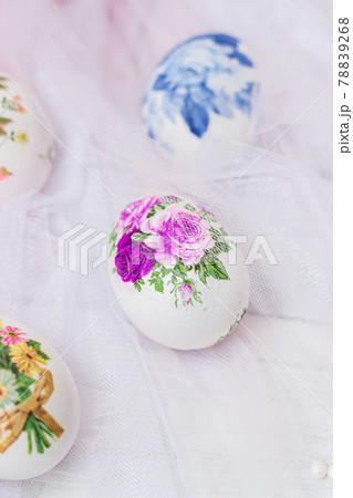 Decorated Easter eggs and flowers on white tulle background; decoupage technique 78839268