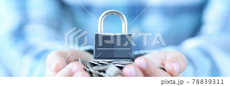 Female hand holding bunch of coins and padlock closeup 78839311