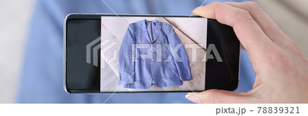 Woman photographing blue jacket on camera phone closeup 78839321