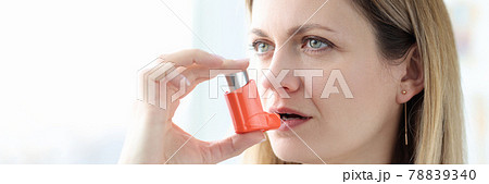 Sick woman holding hormone inhaler near mouth Sick woman holding hormone inhaler near mouth 78839340