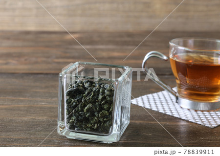 ガラスキューブ容器に入れたウーロン茶葉と一杯のウーロン茶 ガラスキューブ容器に入れたウーロン茶葉と一杯のウーロン茶 78839911