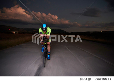 triathlon athlete riding bike fast at night triathlon athlete riding bike fast at night 78840643
