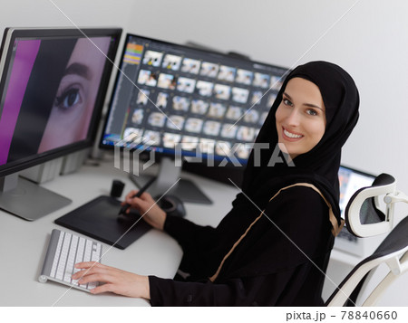 Muslim female graphic designer working on computer using graphic tablet and two monitors Muslim female graphic designer working on computer using graphic tablet and two monitors 78840660
