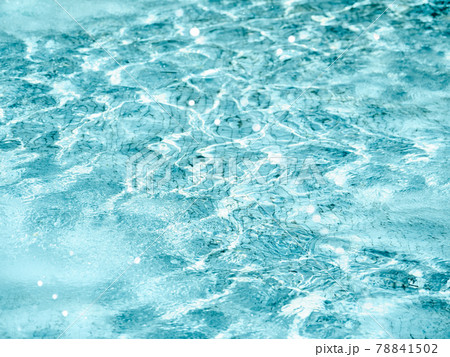 Sun beams on surface of water in swimming pool or fountain with blue mosaic bottom. Abstract background with wavy pattern of clear transparent water. 78841502