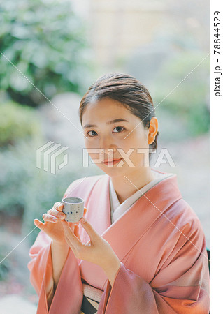 お猪口で日本酒を飲む着物姿の20代女性 78844529