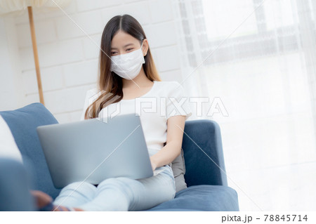 Young asian business woman in face mask work from home on laptop computer online to internet. 78845714