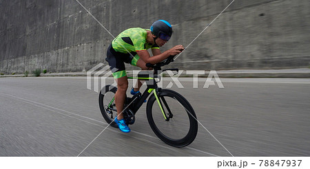 triathlon athlete riding a bike on morning training triathlon athlete riding a bike on morning training 78847937