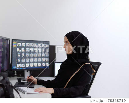 Muslim female graphic designer working on computer using graphic tablet and two monitors Muslim female graphic designer working on computer using graphic tablet and two monitors 78848719