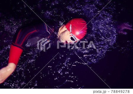 real triathlon athlete swimming in dark night real triathlon athlete swimming in dark night 78849278