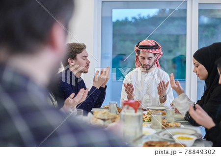 Muslim family making iftar dua to break fasting during Ramadan. Muslim family making iftar dua to break fasting during Ramadan. 78849302