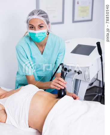 Female cosmetologist during procedure cryolipolyse 78850540
