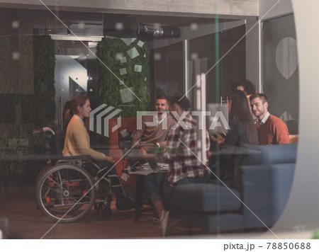 Businesswoman in wheelchair having business meeting with team at modern office Businesswoman in wheelchair having business meeting with team at modern office 78850688