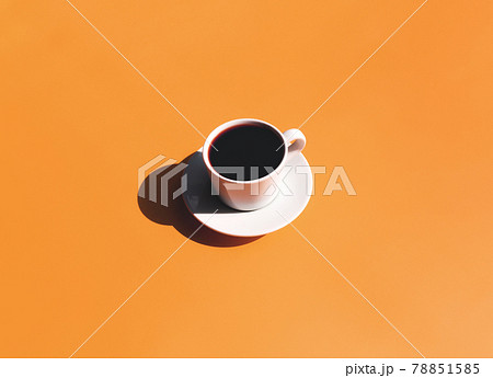 Cup and plate of coffee with shadow of sun on yellow terracotta background 78851585