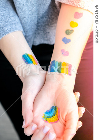 Rainbow LGBTQ flag painted on hand. Support for lgbt community. Honour of pride month. Connecting people, touching hands. Selective focus Rainbow LGBTQ flag painted on hand. Support for lgbt community. Honour of pride month. Connecting people, touching hands. Selective focus 78851696