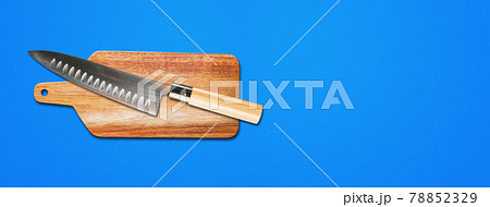 Traditional Japanese gyuto chief knife on a cutting board. Blue banner background Traditional Japanese gyuto chief knife on a cutting board. Blue banner background 78852329