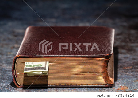 One hundred dollar bookmark note in an old book 78854814