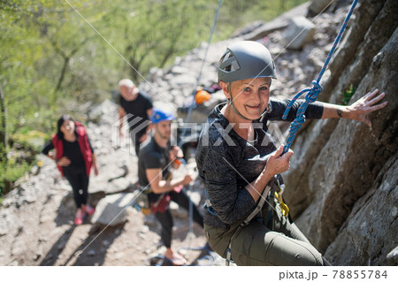 Group of seniors with instructor climbing rocks outdoors in nature, active lifestyle. Group of seniors with instructor climbing rocks outdoors in nature, active lifestyle. 78855784