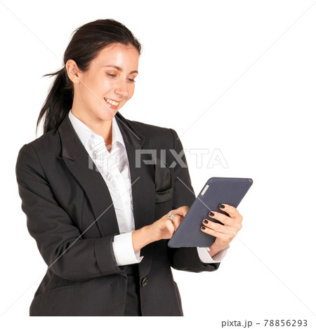 Caucasian business woman in a black suit with a smile and typing on a tablet mobile phone. Portrait on white background with studio light. 78856293