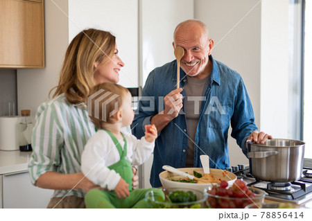 Senior couple with granddaughter indoors at home, cooking. Senior couple with granddaughter indoors at home, cooking. 78856414