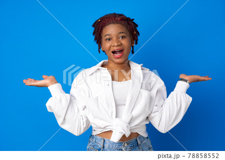 Astonished surprised african american woman against blue studio background 78858552