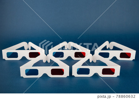 Minimalist composition with classic paper 3D movie glasses on dark blue background. 78860632