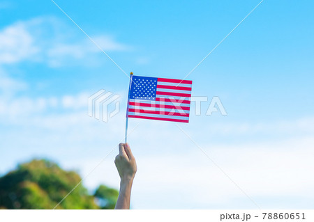 hand holding United States of America flag on blue sky background. USA holiday of Veterans, Memorial, Independence ( Fourth of July) and Labor Day concept 78860651