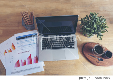 Office laptop business financial document chart and graph on wooden table with coffee cup. Flat lay notebook computer laptop on office desk. No people business graph chart mockup on business workspace Office laptop business financial document chart and graph on wooden table with coffee cup. Flat lay notebook computer laptop on office desk. No people business graph chart mockup on business workspace 78861905
