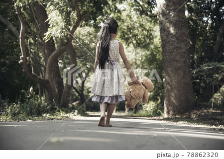 Sad girl hugging teddy bear sadness alone in green garden park. Lonely girl feeling sad unhappy walking outdoors with best friend toy. Autism child play teddy bear best friend. Family violence concept Sad girl hugging teddy bear sadness alone in green garden park. Lonely girl feeling sad unhappy walking outdoors with best friend toy. Autism child play teddy bear best friend. Family violence concept 78862320