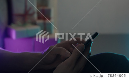 man using smartphone under neon light with chrismas gifts on background man using smartphone under neon light with chrismas gifts on background 78864006