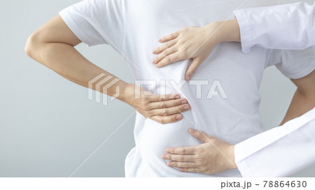 Physical therapy, Female physiotherapist treats back pain for a male patient attending a rehabilitation center, Bone arrangement, Non-surgical medical treatment, Modern medical techniques. 78864630
