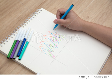 Photo of student hand using felt tip pen to draw chart on the notebook for homework Photo of student hand using felt tip pen to draw chart on the notebook for homework 78865467
