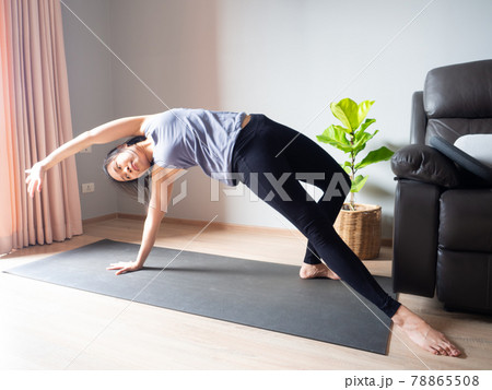 wild thing Camatkarasana yoga pose asian woman home workout fitness body weight exercise health training sport healthy lifestyle activity wellness care on mat indoors natural light selective focus 78865508