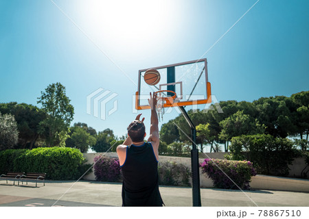Male sportsman playing basketball throwing the ball at playgroun 78867510
