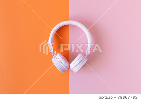 Pink headphones on double pink and orange background. 78867785