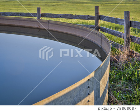 cattle water tank in a green prairie 78868087