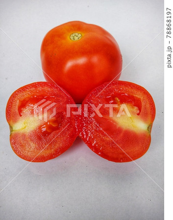 Two  red tomatoes and one of cutting halves with white background.  78868197