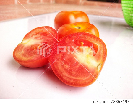 Three red tomatoes one of cutting halves .  Three red tomatoes one of cutting halves .  78868198