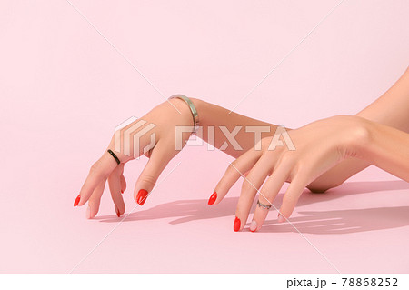 Womans hands with red manicure on pink background. Manicure design trends 78868252