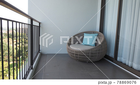 Outdoor beach chair on the hotel room balcony or terrace which made from natural wood called rattan and brown color round shape and look luxury for relaxing or sleeping or for party. 78869076