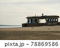 An old abandoned landing stage on an empty beach. Broken wooden building on the shore. 78869586