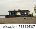 An old abandoned landing stage on an empty beach. Broken wooden building on the shore. 78869587
