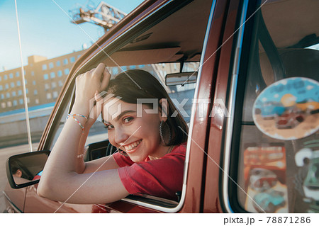 Girl wearing stylish sunglasses looking at the window while sitting the driver's seat 78871286