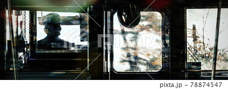 View from inside a train of the driver and his cab. 78874547