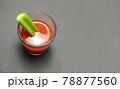 tomato juice in a glass with celery stick on gray wooden background 78877560