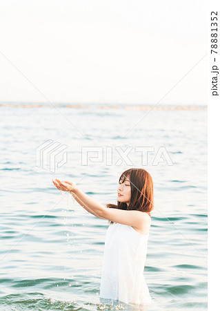 海に入るワンピースの女性 の写真素材