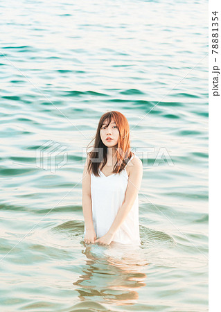 海に入るワンピースの女性 の写真素材