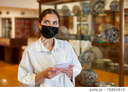 Woman wearing face mask observing artworks in museum Woman wearing face mask observing artworks in museum 78882810