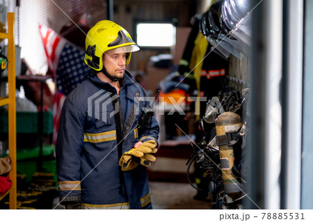 Caucasian fireman or firefighter man stand and hold the glove and look on right side also stay room Caucasian fireman or firefighter man stand and hold the glove and look on right side also stay room 78885531