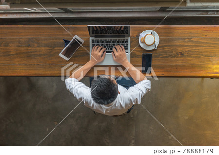 Asian businessman working at cafeteria with his laptop Asian businessman working at cafeteria with his laptop 78888179